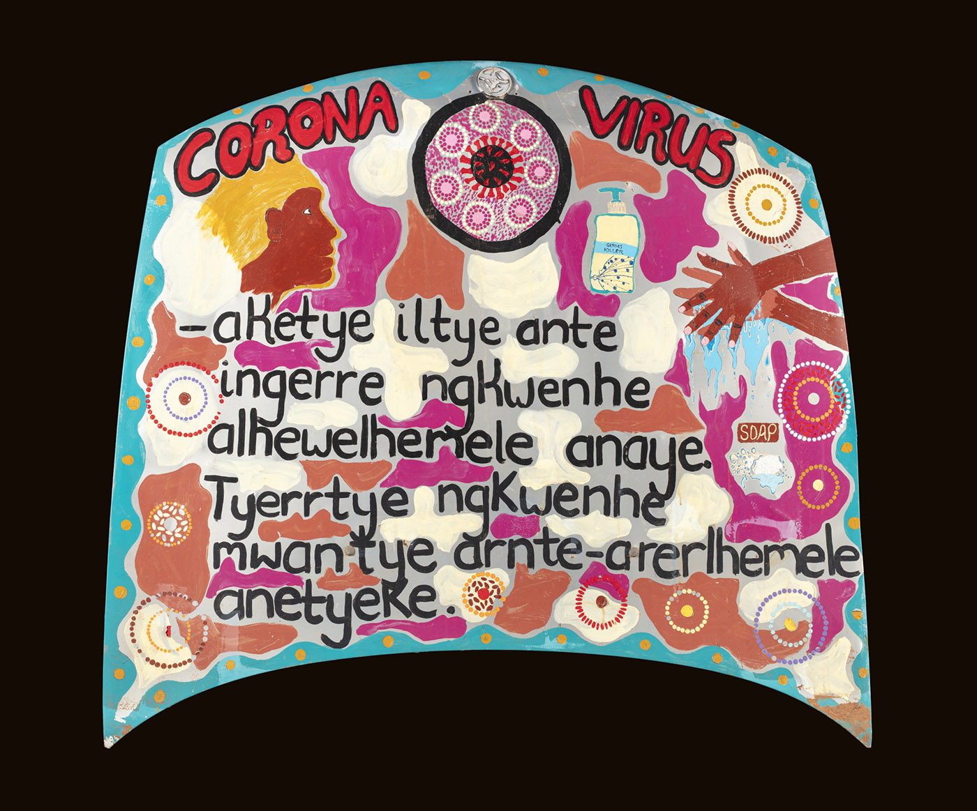 A hand painted car bonnet. The Car bonnet is painted in blue, red, white, yellow and orange. Black text shares COVID-19 messaging in Arrernte language. - click to view larger image