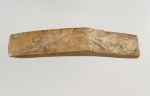 Long adze blade, 14.5cm long, and made of a yellowish limestone. The upper and lower surfaces of the sharp edge are rectangular.