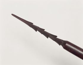 Spear made of brown wood and polished. The point is 24cm long with six rows of three barbs each.