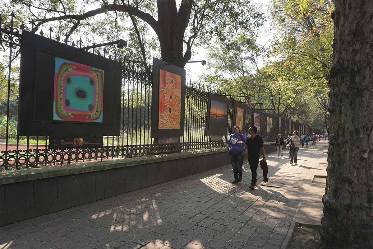 Large graphic panels installed on perimeter fence with pedestrians walking by