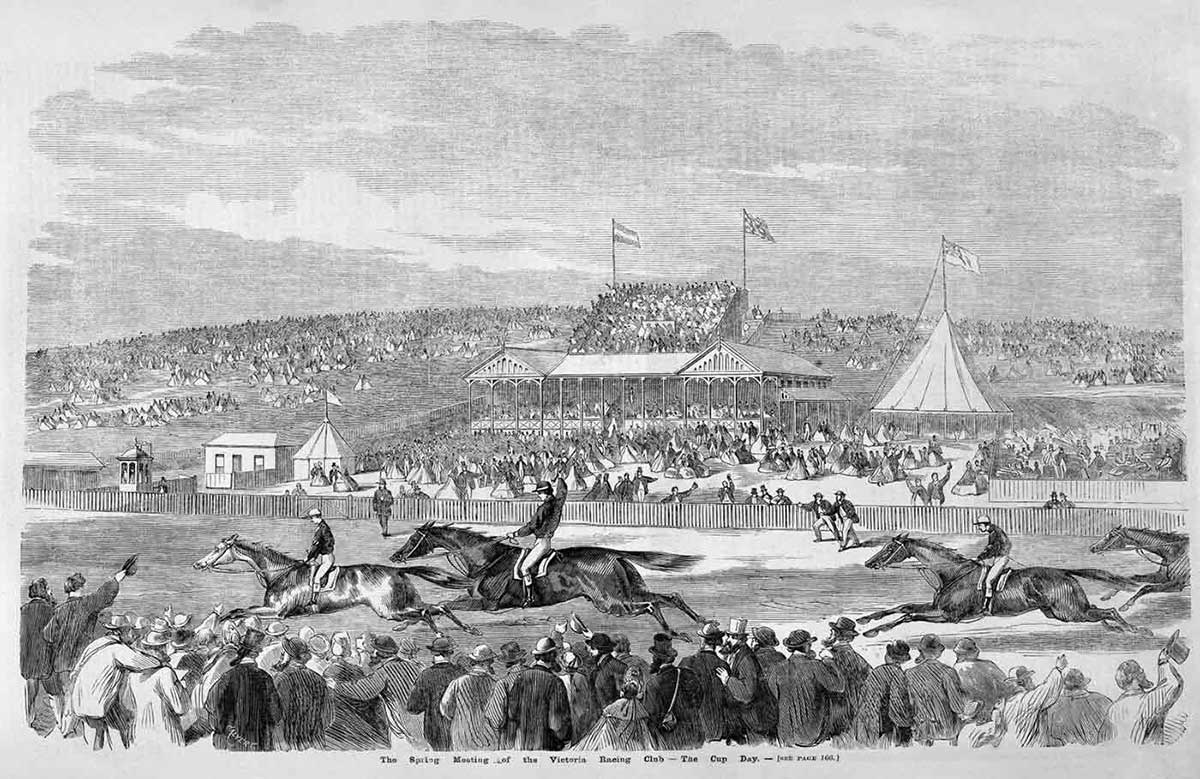 Black and white print showing four horses being ridden by jockeys on a track. Large crowds of people stand on either side of the track, with pavilions and flags visible in the distance.