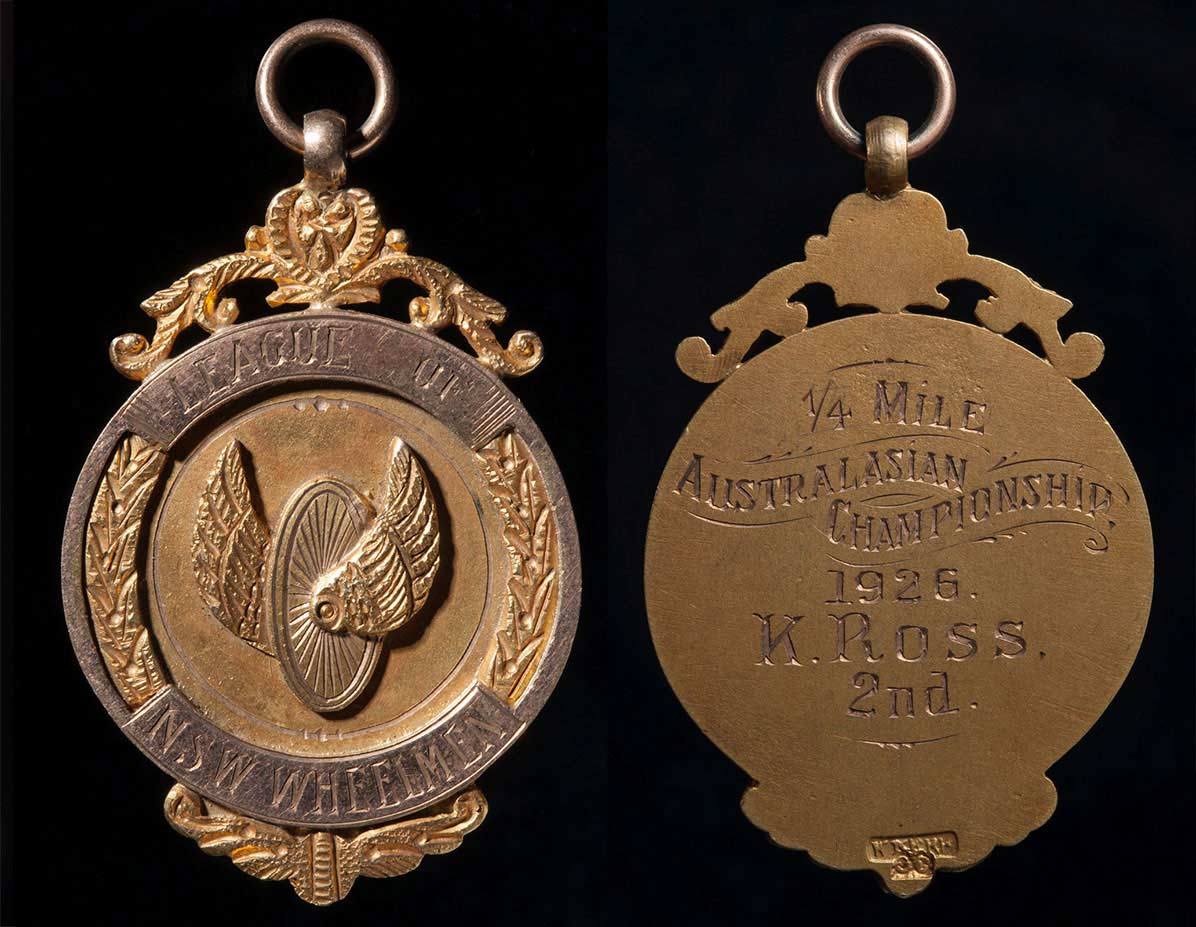 Gold coloured circular medal with raised and engraved decoration and text inscribed on the front and the back. - click to view larger image
