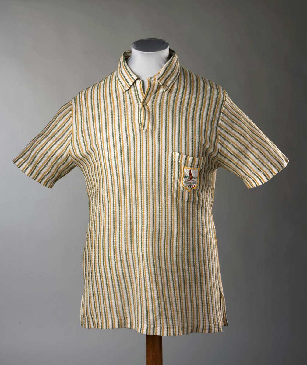 Short-sleeved, V-necked while collared shirt with pale green and yellow vertical stripes. A pocket on the right breast bears an embroidered patch showing a brown kangaroo standing above the five Olympic rings. The words 'ROME 1960' are embroidered in green beside the kangaroo. - click to view larger image