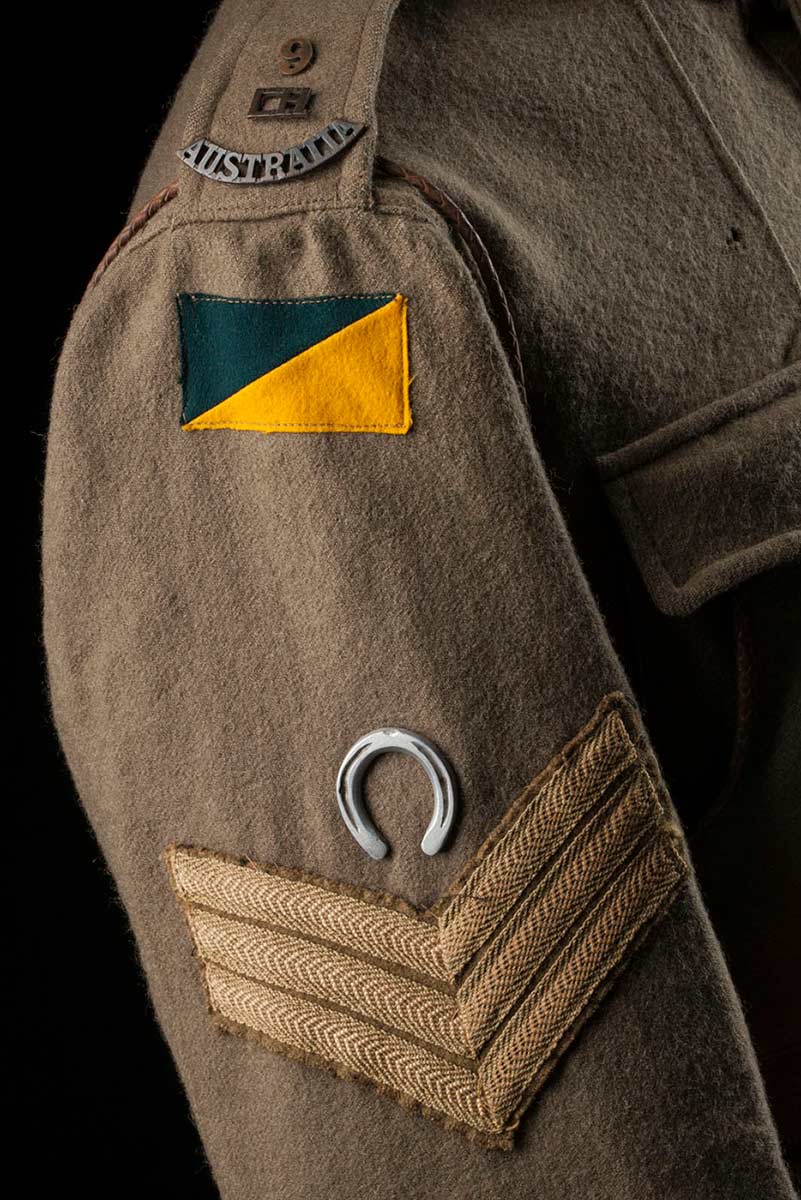 Detail of James Taylor's tunic showing the 9th Light Horse insignia, the later colour patch, horseshoe motif and chevrons. - click to view larger image