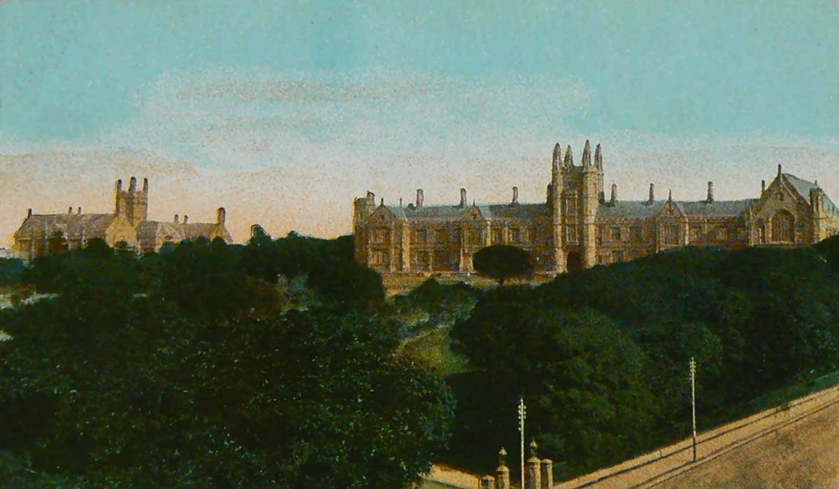 An unused postcard featuring a colour image of buildings at Sydney University with gardens in the foreground.