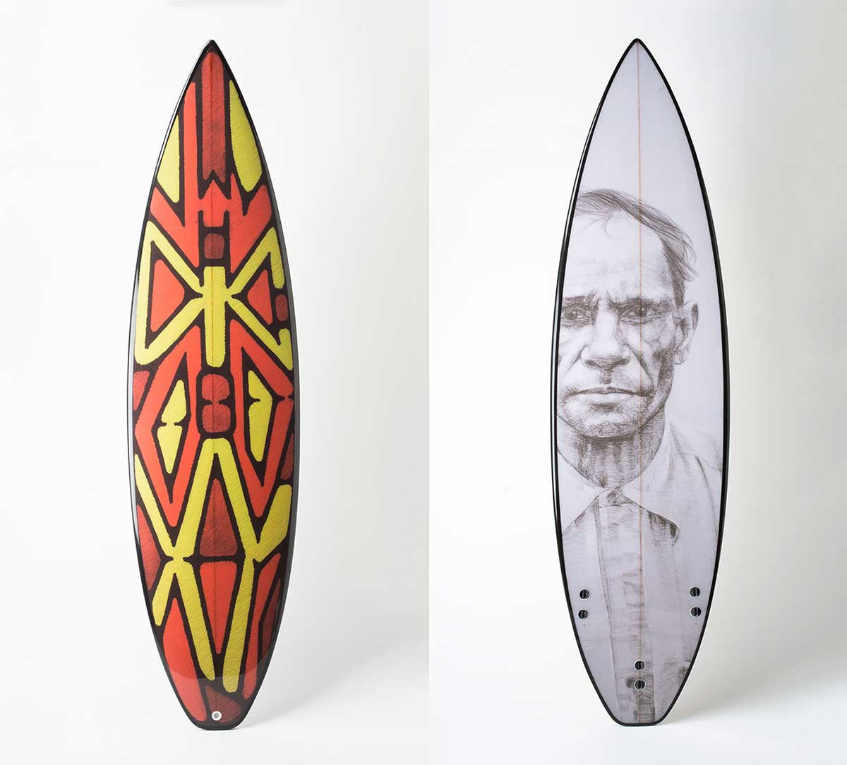 From left to right of the image, front and back of a surfboard and an etching resembling a shield. - click to view larger image