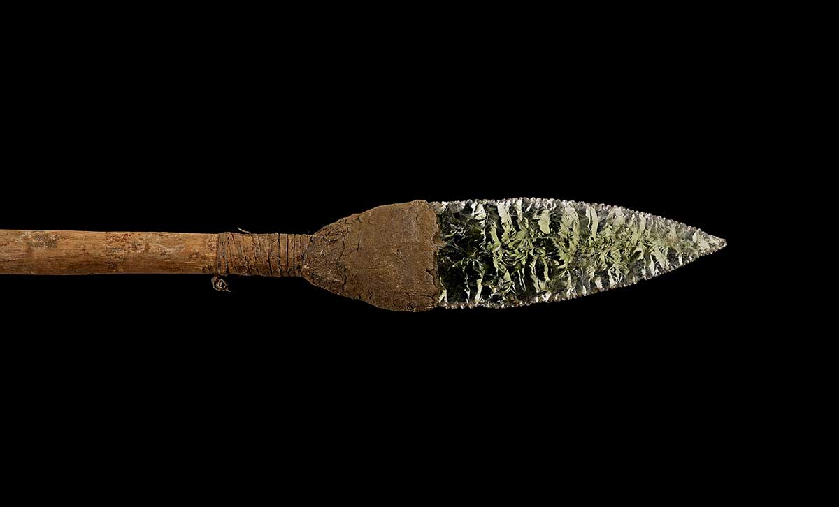 Upper part of spear consisting of wood foreshaft ending in pale green glass point attached with gum and tendon binding. - click to view larger image