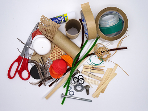 A range of objects including: cardboard tubes, toothpicks, sticky tape, bottle tops, pipe-cleaners, coloured paper, glue, pencils and textas.