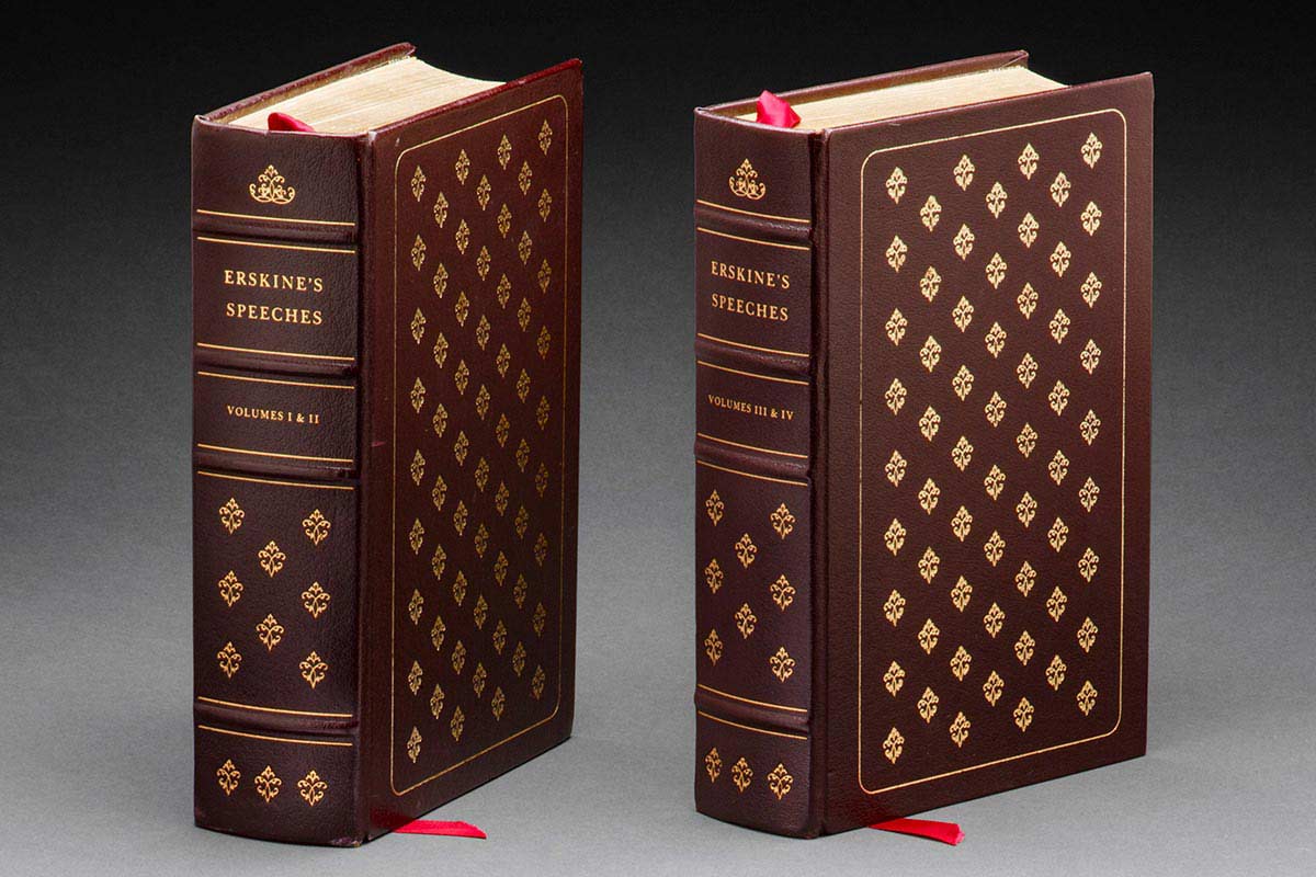 A leather bound hard cover book containing two volumes of speeches by Lord Erskine. The cover is burgundy with gold tooling, and text on the spine reads 'ERSKINE'S SPEECHES / VOLUMES I & II'. The end papers are marbled.