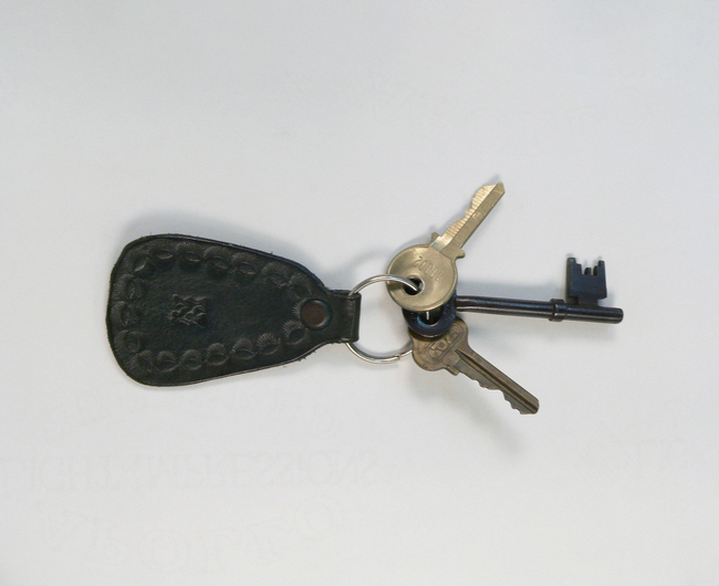 Colour photograph of three keys attached to a ring and embossed leather tab. - click to view larger image
