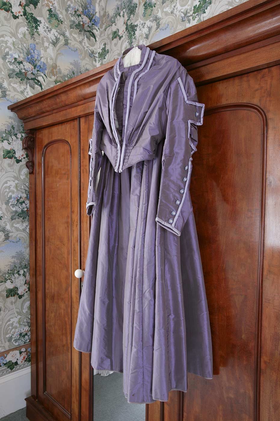 Purple period dress hanging from a wardrobe. - click to view larger image