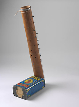 A blue tin with 'DANTE' written at the top and 'MINERVA SA' at the base. An image of a man dressed in red appears in a central circle on the tin. Bamboo tubing extends from one end.
