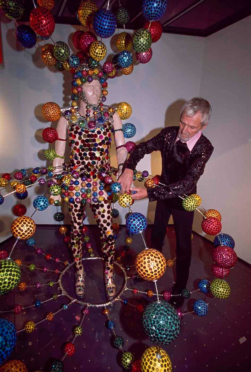 Man attaching sequinned ball to costume. - click to view larger image
