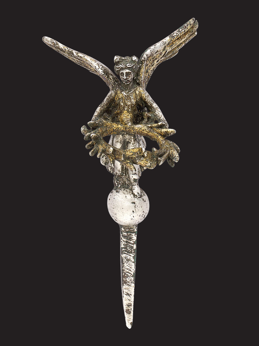 Metal pin featuring a crude design of an angel holding a wreath. - click to view larger image