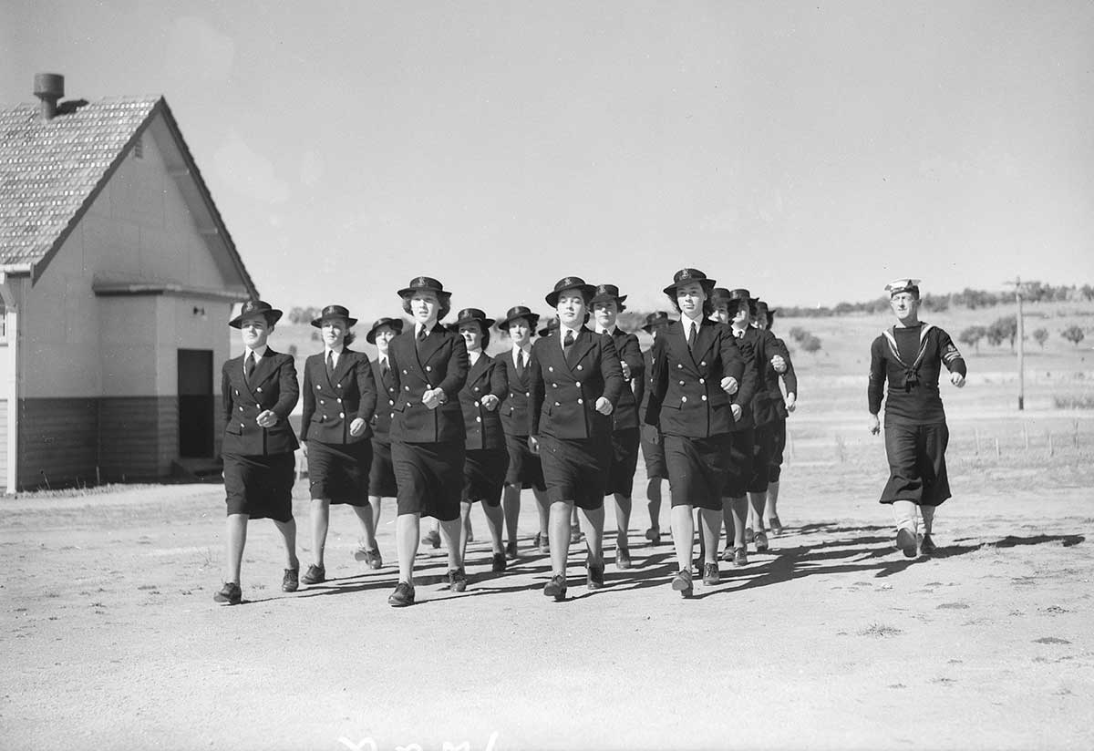 A group of women in military uniform marching outside.