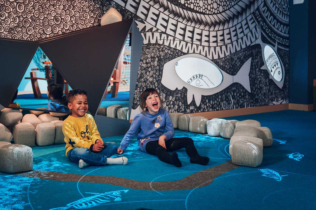 Children playing amongst digital projections of sea life in the Discovery Centre. - click to view larger image