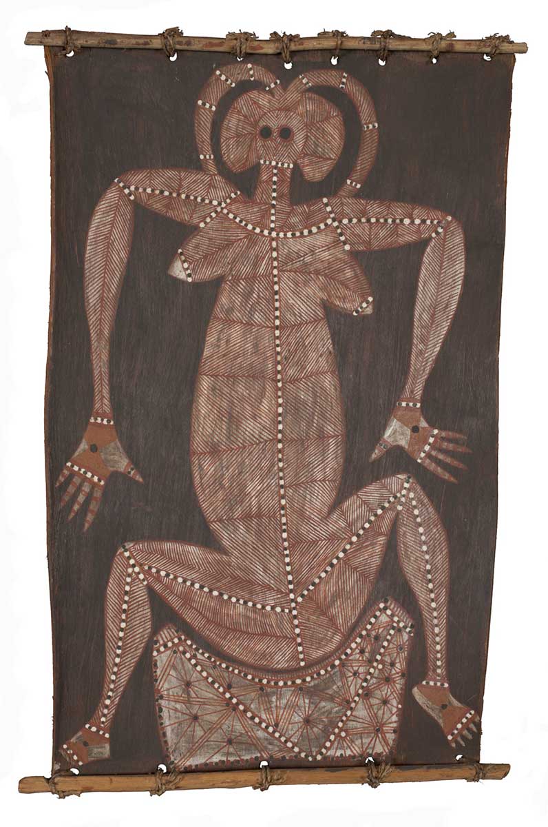 A bark painting worked with ochres on bark and on wooden restrainers. It depicts a seated female spirit figure with raised and bent legs and arms. There is a curved form around her head and she is seated on a rectangular shape The figure is painted in herringbone stripes of white on red ochre and with red lines with white dots. The painting has a black background. - click to view larger image