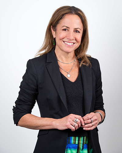 Photograph of Clare Wright. Clare has shoulder lenght brown hair and is wearing a black jacket and shirt. She is smiling at the camera.