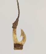 Fishhook made of two pieces of bone bound together with a string made from plant materials. The barb located on inner side of hook with a brown fishing line attached.