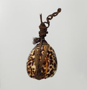 Lure that consists of a brownish, cone-shaped piece of stalactite, securely fastened to a large leopard cowry shell, a twig for a tail all tied together with braided coconut fibres.