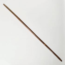 Digging stick made of a dark brown heavy wood.