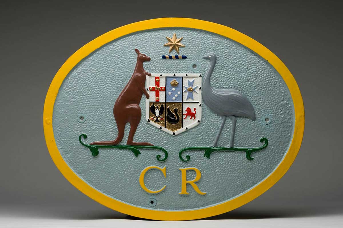 Oval plate with Australian coat of arms with the letters CR underneath. - click to view larger image