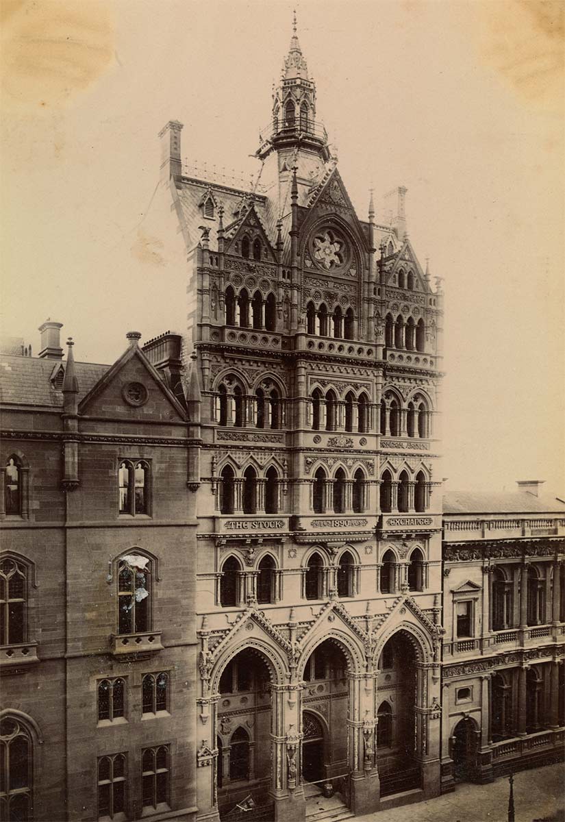 An ornate gothic building seven or eight storeys high with lower buildings on either side