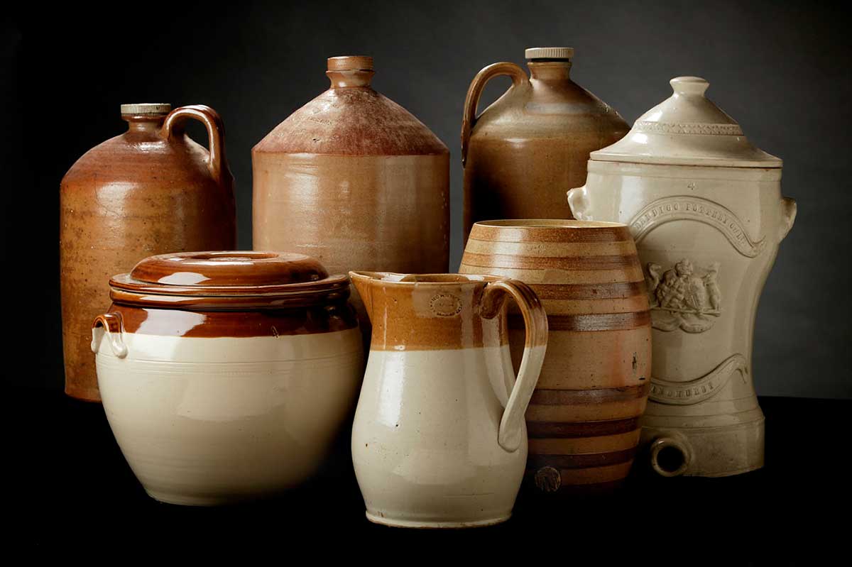 Just some of the diverse wares produced at Bendigo Pottery between 1872 and 1921. These include three salt-glazed demijohns, about 1888, a white glazed ceramic water filter, about 1872, a ceramic pickle jar with dark brown and honey-coloured bands, about 1882, cream and honey-coloured bristol ware jug, about 1882, and a bristol ware bread crock with cream body and honey-coloured band, about 1921.