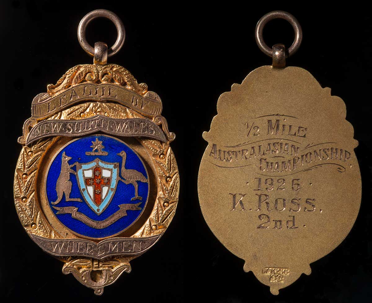 Gold coloured circular medal with embossed coat of arms and text inscribed on the front and the back. - click to view larger image