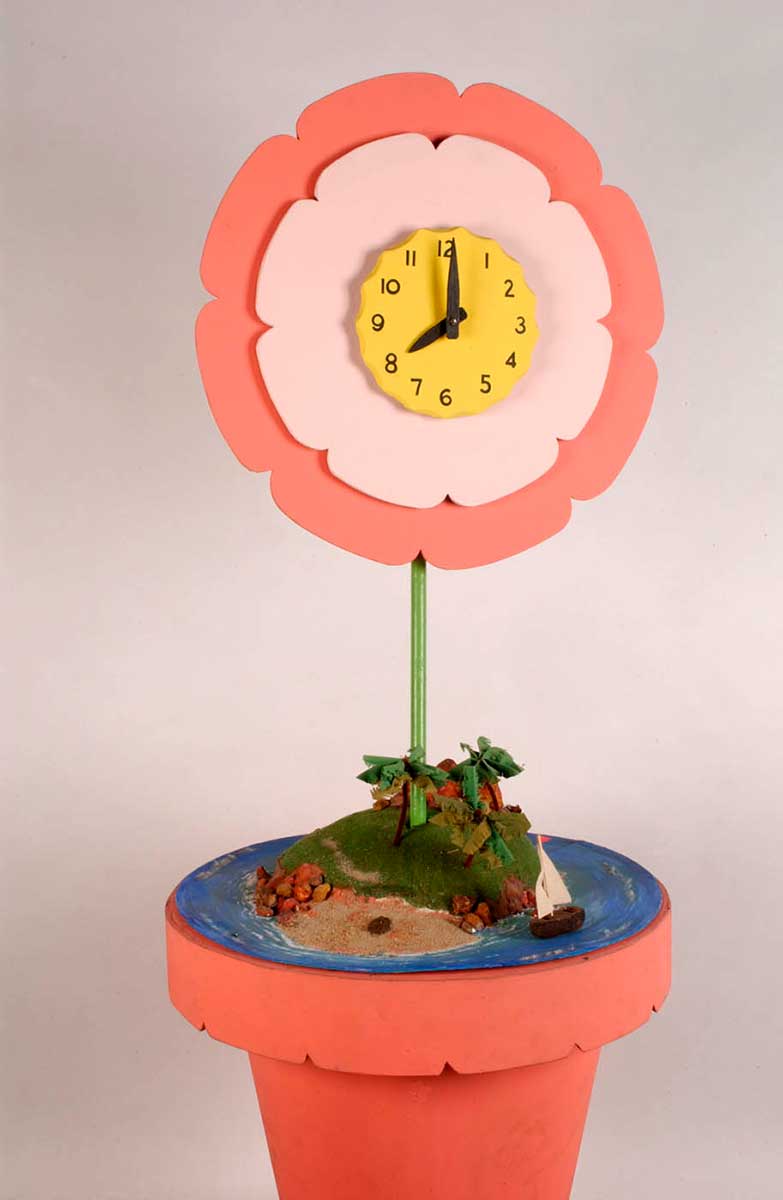 A large clock in the shape of a flower in a pot. The pot and petals are painted pink and the stem is painted green. A large yellow clock face is positioned in the centre of the flower head, which has black plastic numbers and hands. - click to view larger image