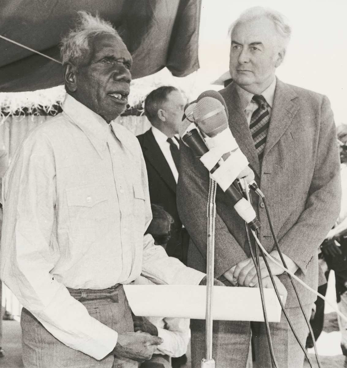 Two men standing at a microphone. - click to view larger image