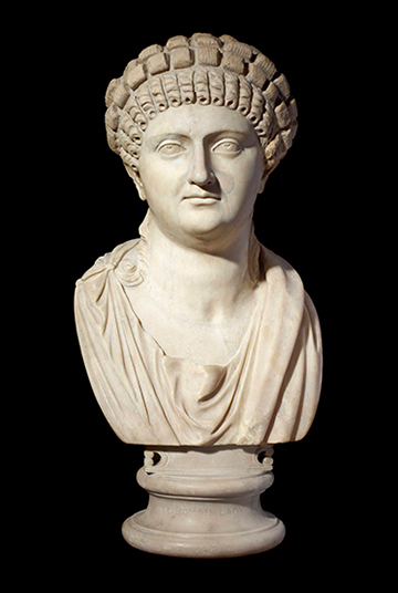 Photo of a female statue head with a black background.