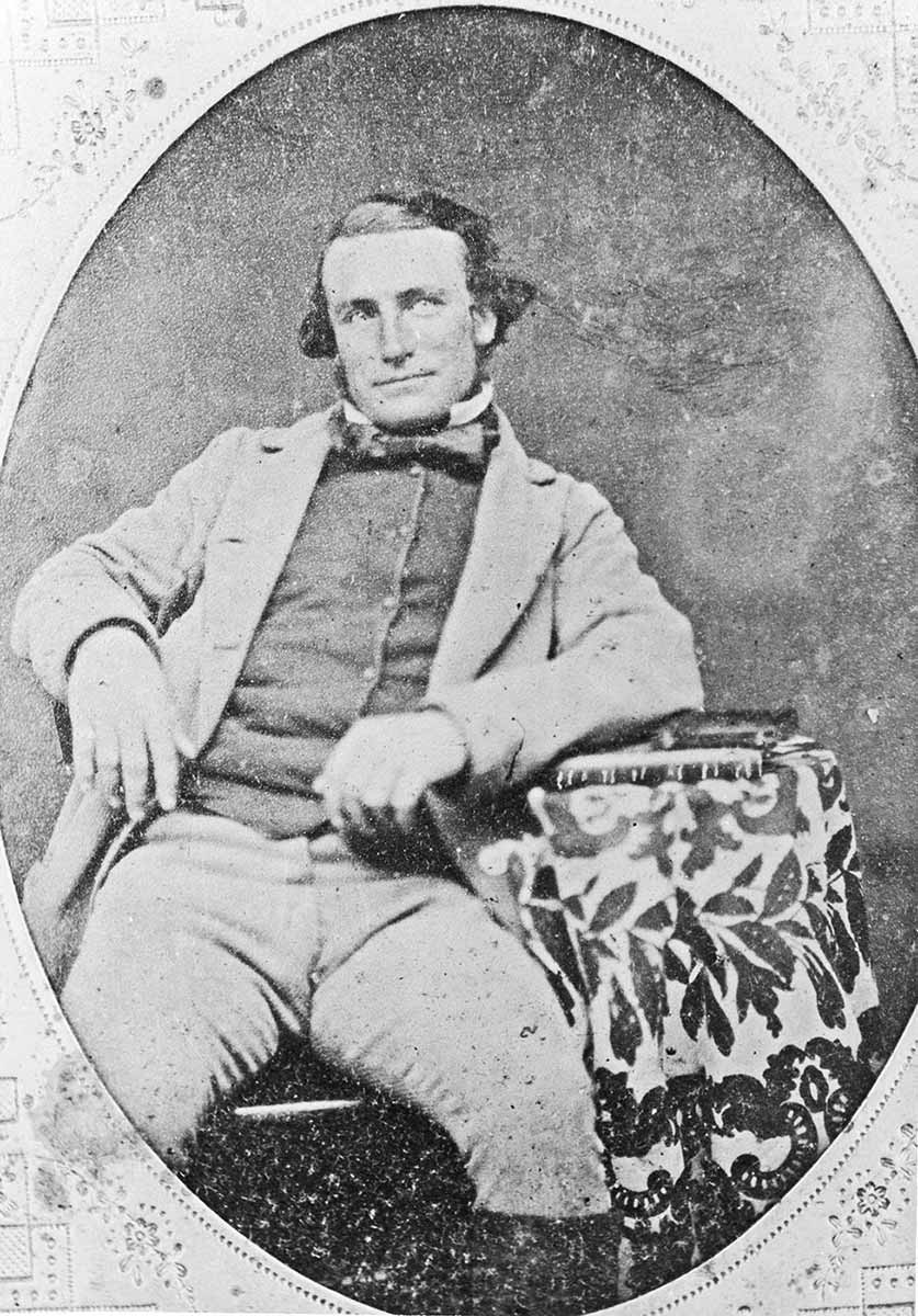 old studio photograph of man in his thirties sprawled on a chair with his arm resting on a sidetable - click to view larger image