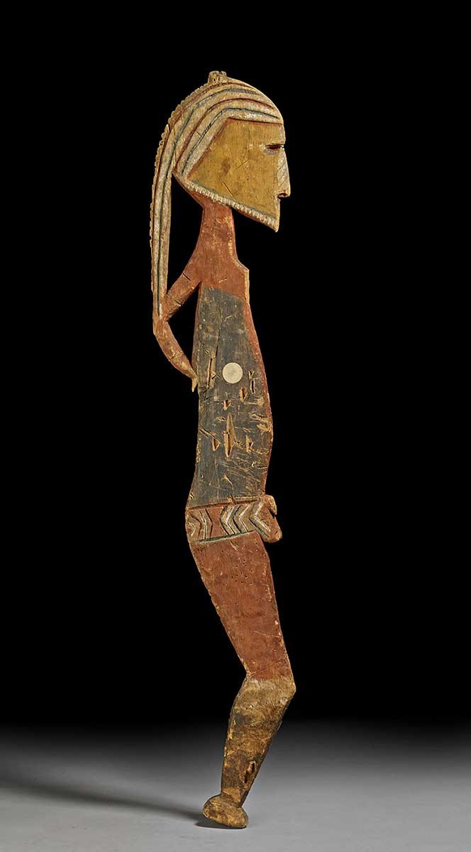 Human figure carved in profile from a flat piece of wood. Painted in red, black, yellow, and white patterns. - click to view larger image