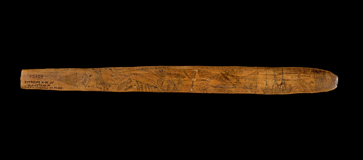 Message stick made of wood featuring etchings and text. - click to view larger image