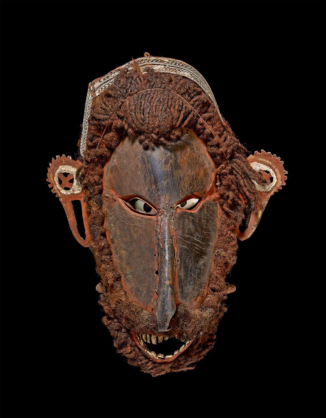 A mask made from turtle-shell plates which have been moulded and sewn into the form of an elaborate human face; hair and beard made from human hair; shell eyes. - click to view larger image