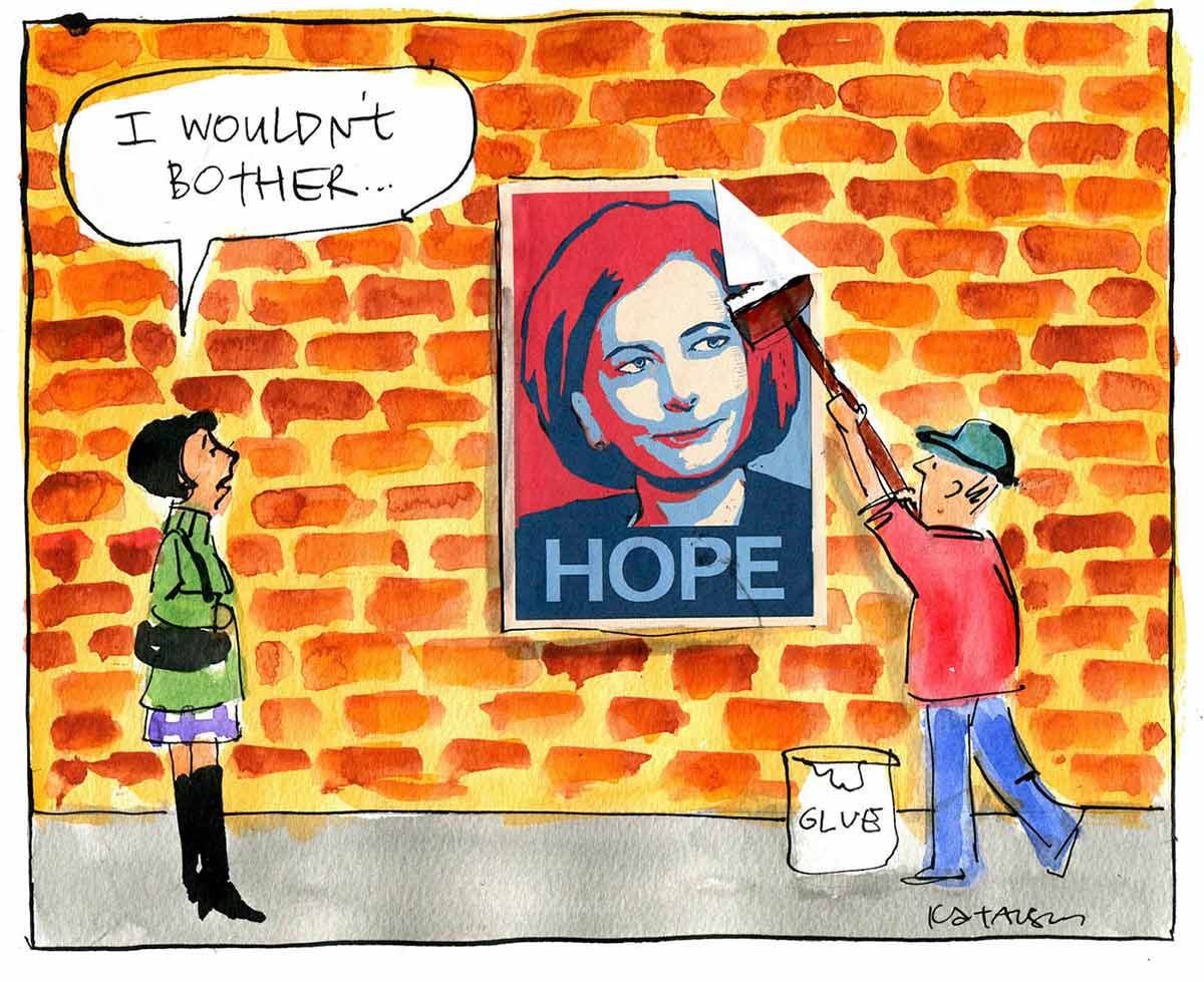 A colour cartoon depicting a man putting a poster up on a brick wall. The poster shows Julia Gillard, in red and blue. The word 'HOPE' is at the bottom of the poster. A woman stands to the left, watching the man. She is saying 'I wouldn't bother ...' - click to view larger image