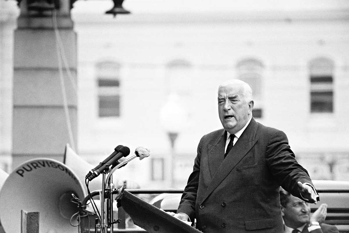 Black and white photo of Robert Menzies on a podium delivering a speech.