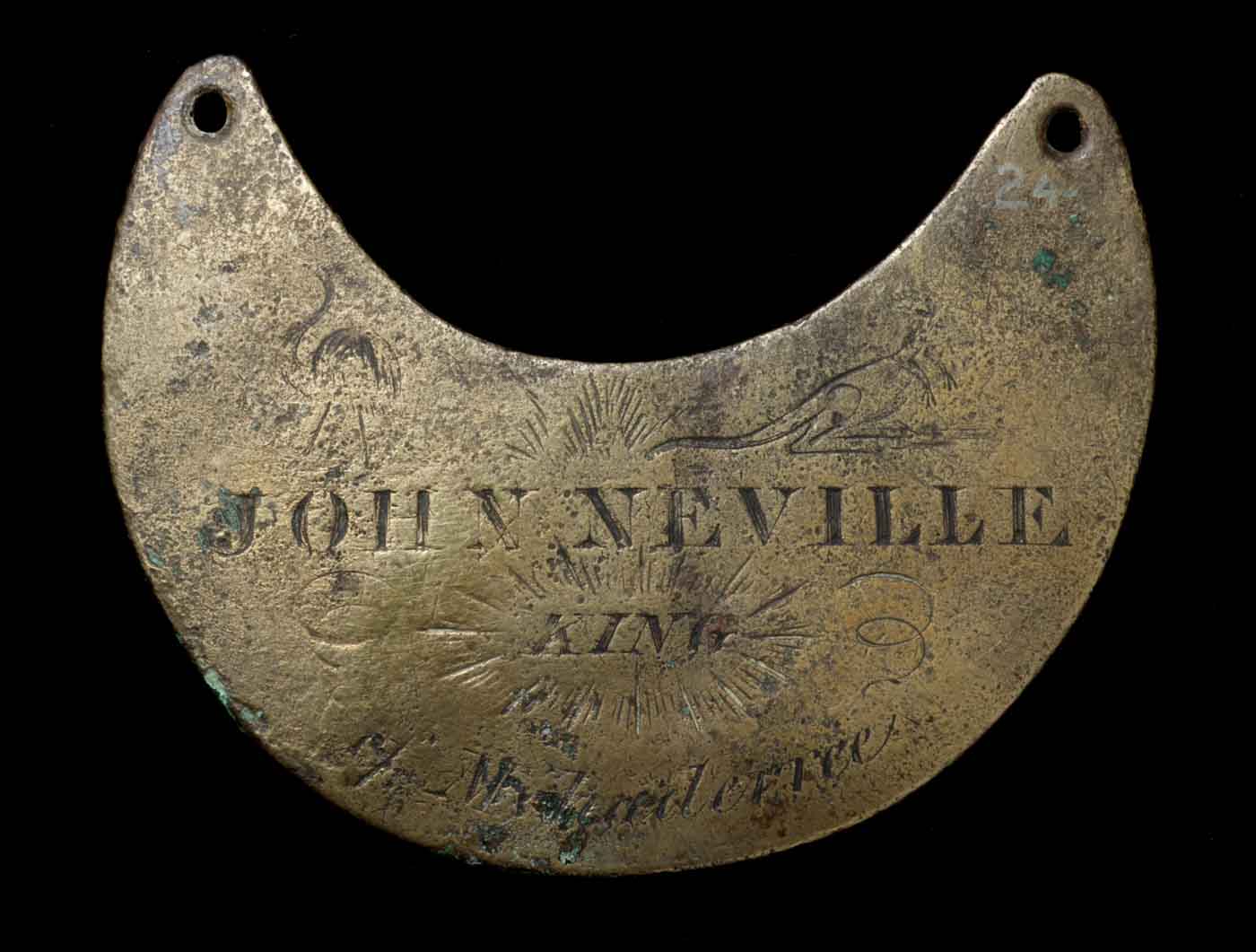 Engraved breastplate with images of a kangaroo and emu. The surface is pitted and dark around the edges.