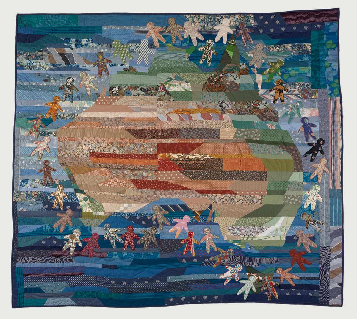 Colour photo of a patchwork quilt featuring human figures surrounding the Australian continent. - click to view larger image