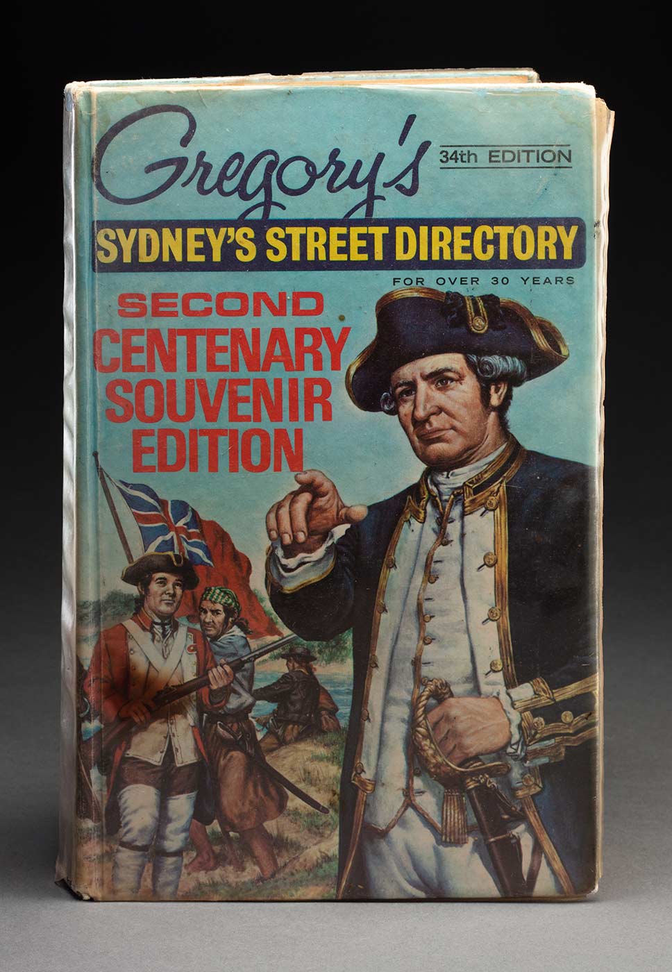 Gregory's 34th edition 'Sydney's Street Directory', second centenary souvenir edition. The front cover features a colour image with Captain Cook in the foreground on the right, and several other men with a flag in the background on the left. The cover has a plastic jacket. - click to view larger image