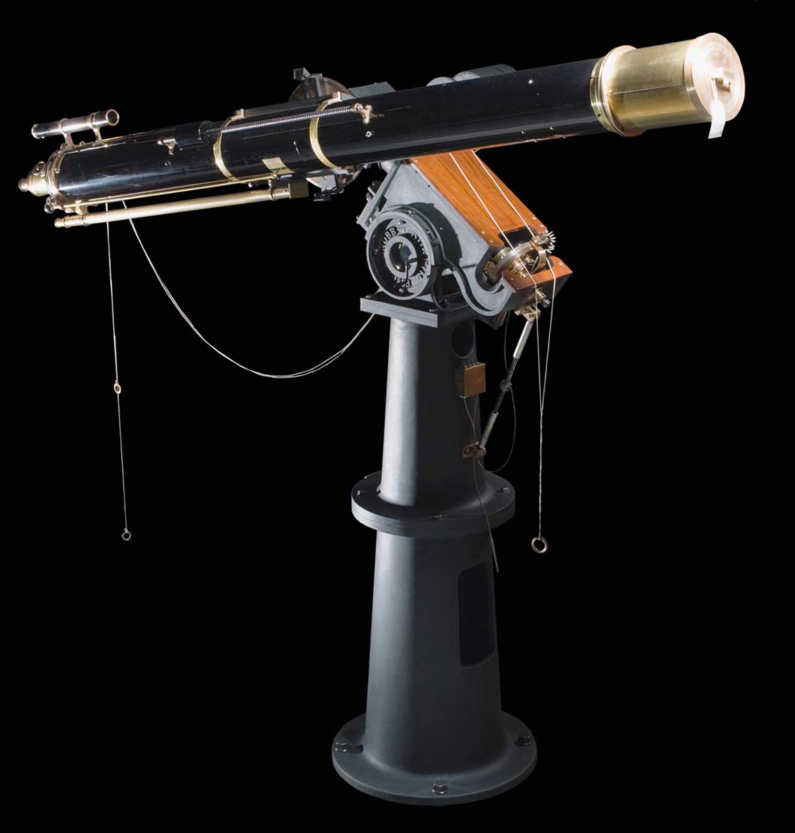 1883 Grubb Refractor Telescope made from brass. The telescope has a tapering cast iron base in two parts. The Polar Axis Assembly is made from cast iron and brass, and comes with three separate disc weights. The Declination Access Assembly is made from cast iron and steel and comes with a cylindrical weight with a pulley on the top. - click to view larger image