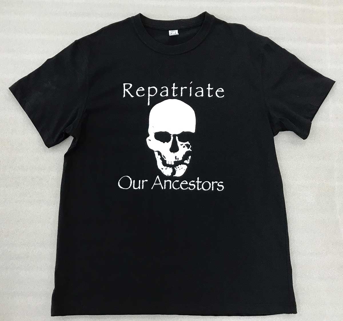 Black T-shirt featuring a design with a skull and the words 'Repatriate Our Ancestors'. - click to view larger image