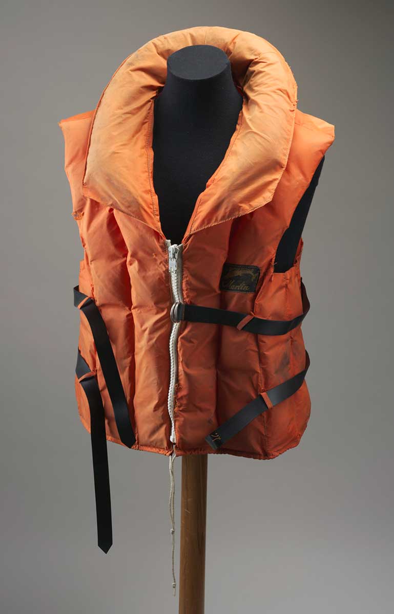 An orange fabric life jacket with a white zip at the front, two black plastic belts around the chest and waist and a drawstring around the bottom edge. - click to view larger image