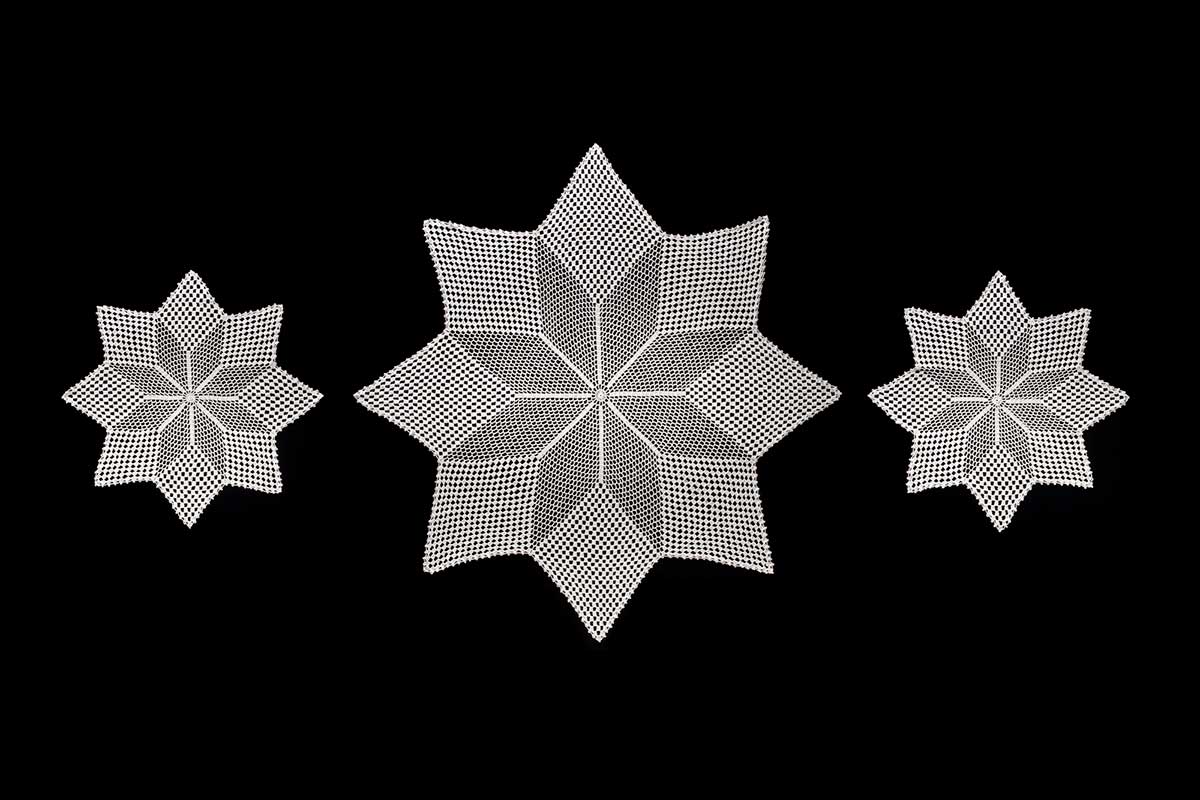 Three-piece white table setting on a black background. The pieces are in the shape of eight-pointed stars, with the larger piece in the centre and two smaller pieces either side. - click to view larger image