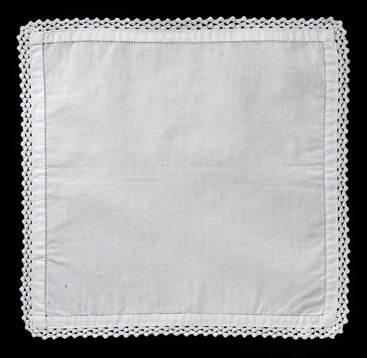Square-shaped white woven handkerchief with fine crocheted detailing at the edges. - click to view larger image