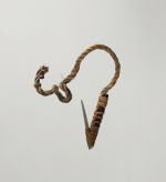 Fishhook with shank made of black wood, fish bone point, with short, twisted cord, and lashing made of plant material.