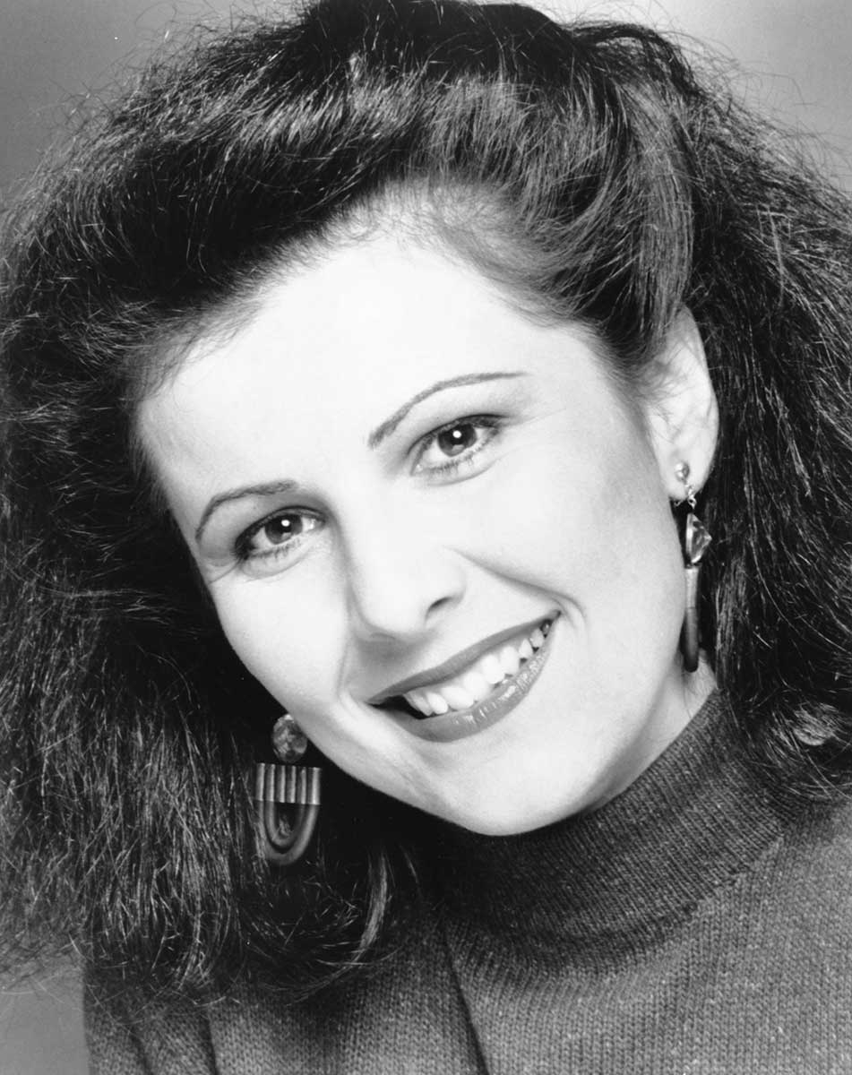 studio portrait of a young Mary Kostakidis smiling and looking directly at the camera
