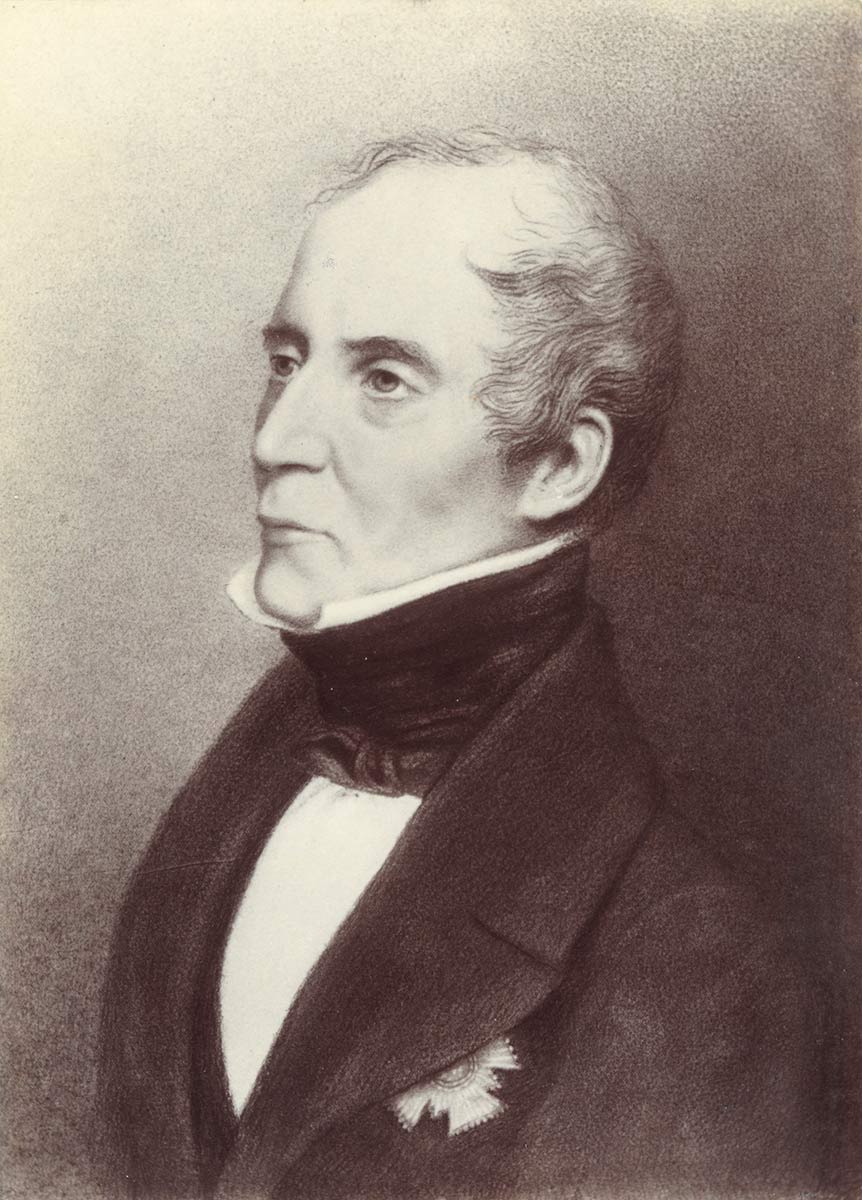 Three quarter profile black and white image of a middle-aged man in formal wear with a black cravat and black coat. The man’s expression is serious, even severe. - click to view larger image