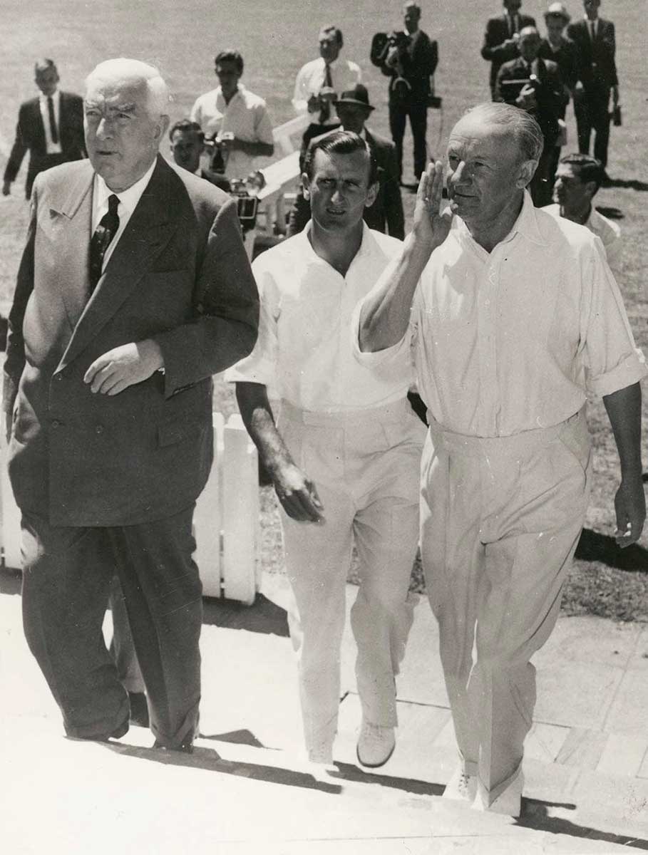 Menzies in suit and Dexter and Bradman in cricket whites to his left - click to view larger image